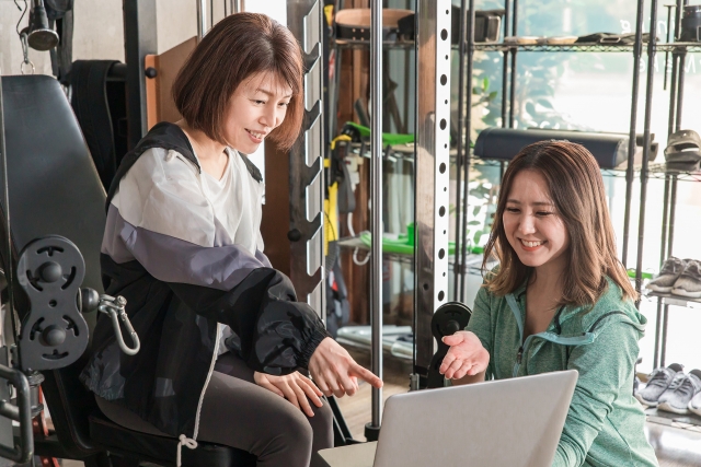 食事指導を受ける女性とトレーナー